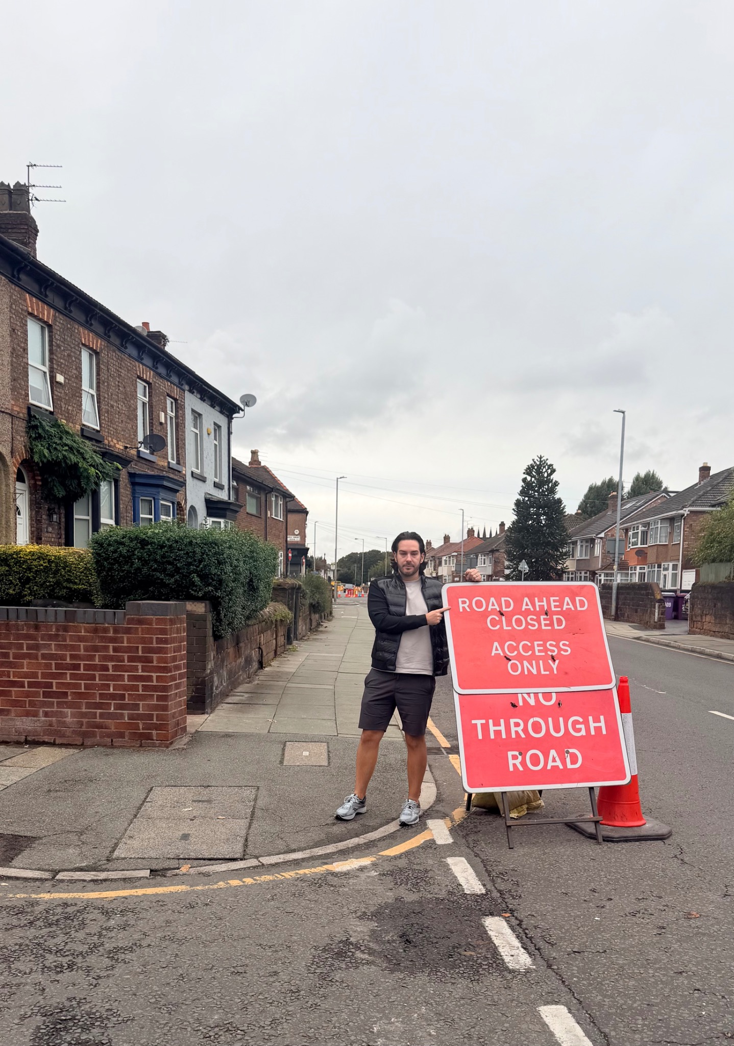 David Brookes-Lennon beside a road closure sign