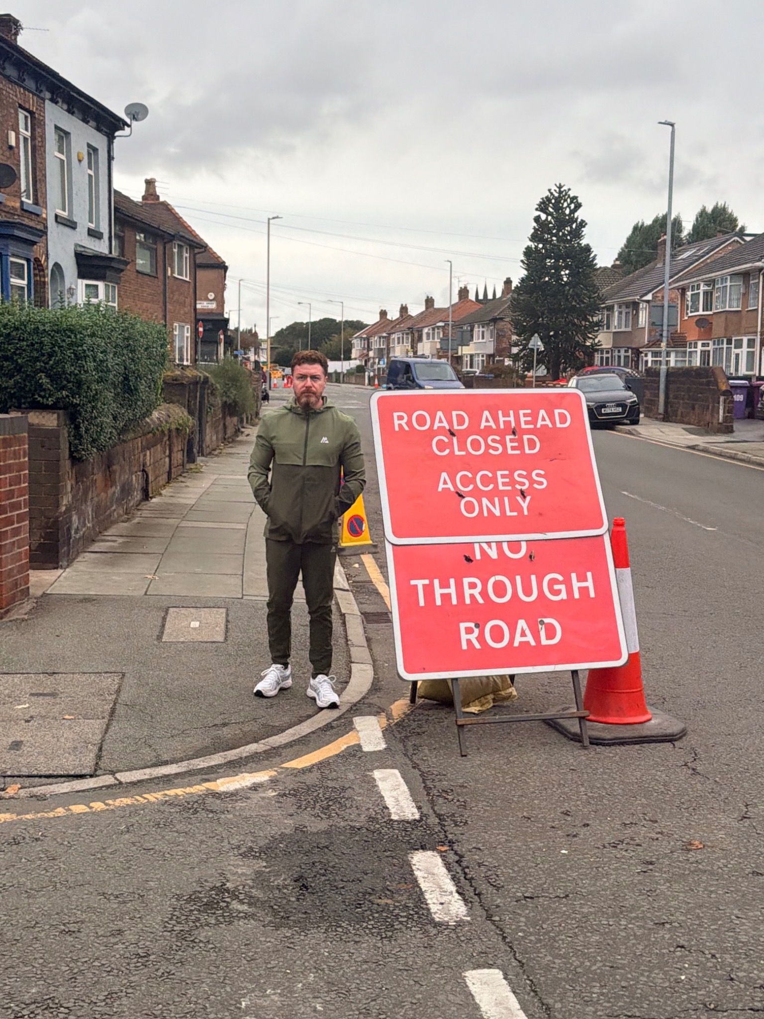 Phil Brookes-Lennon beside a road closure sign